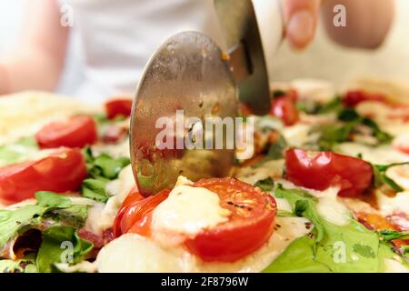 Pizza mit Käse, Tomaten, Spinat und Räucherwurst Stockfoto