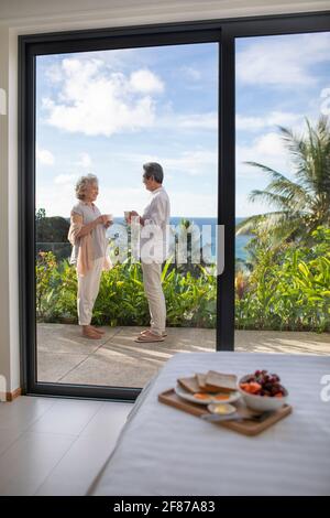 Glückliches Ehepaar, das Kaffee auf dem Balkon trinkt Stockfoto