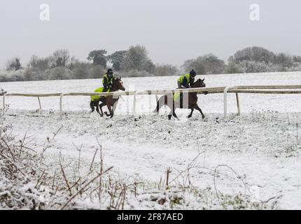 Epsom Downs, Großbritannien. April 2021. Rennpferde trainieren im Schnee auf Epsom Downs. Quelle: Nigel Bramley/Alamy Live News Stockfoto