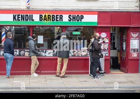 Chichester, Großbritannien. April 2021. Männer stehen vor einem Barbiere, während der Einzelhandel und andere Unternehmen wieder geöffnet werden, da die Beschränkungen für die Sperrung durch England gelockert werden. Kredit: Paul Terry Foto/Alamy Live Nachrichten Stockfoto