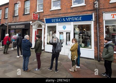 Chichester, Großbritannien. April 2021. Die Menschen stehen vor einem Barbiere, während der Einzelhandel und andere Unternehmen wieder geöffnet werden, da die England-Sperrbeschränkungen gelockert werden. Kredit: Paul Terry Foto/Alamy Live Nachrichten Stockfoto