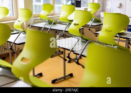 Heitersheim, Deutschland. April 2021. In einem leeren Klassenzimmer einer weiterführenden Schule stehen Stühle auf Tischen. Aufgrund der rasch steigenden Corona-Infektionszahlen kehren Grundschüler und auch die 5. Und 6. Klasse in der ersten Woche zum Fernunterricht zurück. Für die Klassen 1 bis 7 soll es nur Notfallversorgung für die Kinder geben, deren Eltern sie dringend benötigen. Quelle: Philipp von Ditfurth/dpa/Alamy Live News Stockfoto