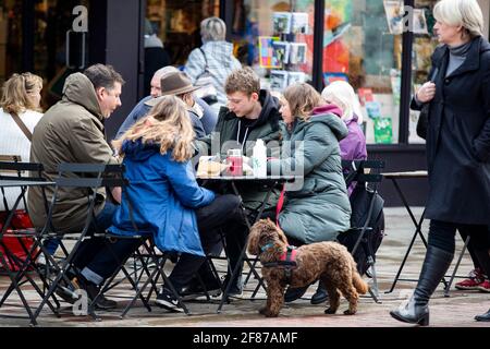 Chichester, Großbritannien. April 2021. Mitglieder der Öffentlichkeit genießen Erfrischungen außerhalb eines Cafés, da nicht unbedingt erforderliche Geschäfte und andere Unternehmen wieder geöffnet werden, da England Lockdown-Beschränkungen gelockert werden. Kredit: Paul Terry Foto/Alamy Live Nachrichten Stockfoto