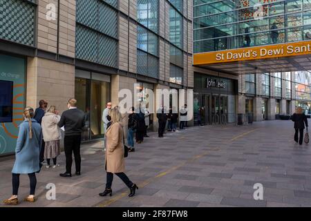 Cardiff, Wales, Großbritannien. April 2021. Die Einkäufer stehen vor einem John Lewis-Laden im Einkaufszentrum von St. David im Stadtzentrum von Cardiff, da nicht unbedingt erforderliche Geschäfte wieder geöffnet werden und die Beschränkungen für die Sperrung durch Coronaviren in Wales und ganz Großbritannien weiter lockern. Kredit: Mark Hawkins/Alamy Live Nachrichten Stockfoto