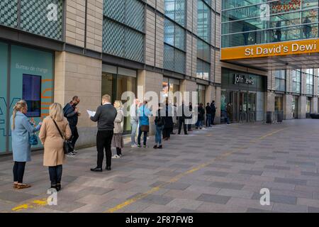 Cardiff, Wales, Großbritannien. April 2021. Die Einkäufer stehen vor einem John Lewis-Laden im Einkaufszentrum von St. David im Stadtzentrum von Cardiff, da nicht unbedingt erforderliche Geschäfte wieder geöffnet werden und die Beschränkungen für die Sperrung durch Coronaviren in Wales und ganz Großbritannien weiter lockern. Kredit: Mark Hawkins/Alamy Live Nachrichten Stockfoto