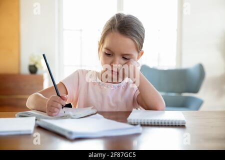 Gelangweilt kleines Mädchen Kind unmotiviert Hausaufgaben machen Stockfoto