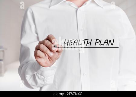 Mann mit Stift unterstreicht die Worte Gesundheitsplan auf einem virtuellen Bildschirm. Stockfoto