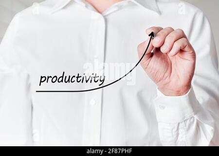 Geschäftsmann mit Stift zeichnet ein aufsteigendes Liniendiagramm mit dem Wort Produktivität auf einem virtuellen Bildschirm. Steigerung der Produktivität im Geschäftskonzept Stockfoto