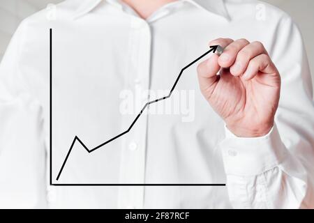 Geschäftsmann mit Stift zeichnet eine steigende Linie Diagramm auf einem virtuellen Bildschirm. Stockfoto