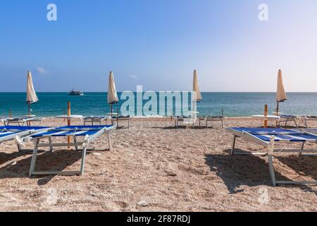 Leere Strandliegen warten auf Urlauber an einem wunderschönen Strand Stockfoto