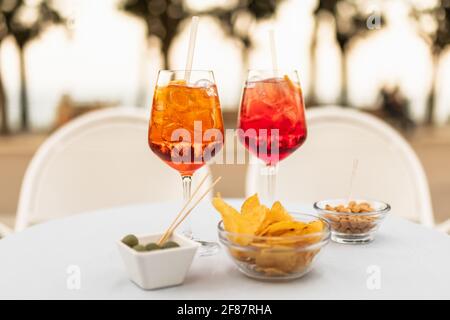 Erfrischende italienische Cocktails mit Snacks auf dem Tisch Sommerabend Stockfoto