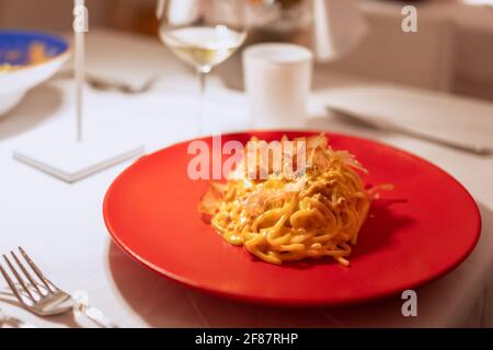 Hausgemachte Pasta mit Fischsauce und Thunfischflocken. Modernes italienisches Rezept (Nahaufnahme, selektiver Fokus) Stockfoto