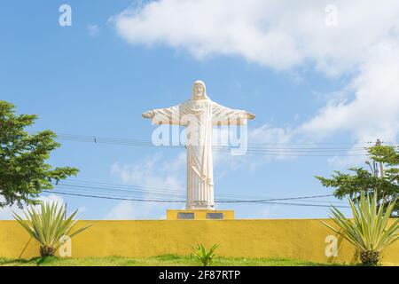 São Roque de Minas - MG, Brasilien - 14. Dezember 2020: Weiße Skulptur Christi mit offenen Armen an einem Kreisverkehr in der Stadt in der Novo Tempo ne Stockfoto