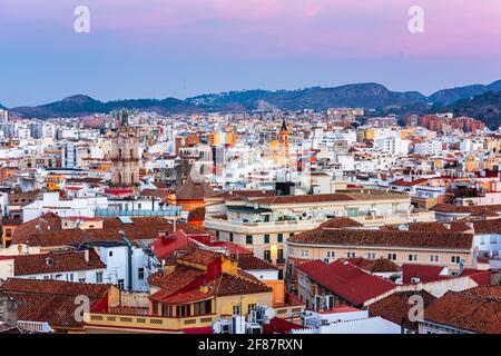 Malaga, Spanien Blick auf die Stadt von einem Dach in der Abenddämmerung. Stockfoto