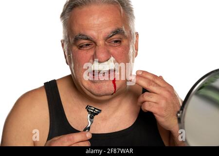 Nervöser Mann mittleren Alters mit Blut im Gesicht Weißer Hintergrund Stockfoto