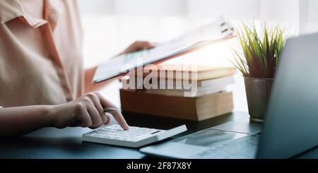 Geschäftsfrau mit Rechner für die mathematische Finanzierung auf Holztisch im Büro, Steuern, Buchhaltung, Statistik zu Hause Rechenschaft Konzept. Stockfoto