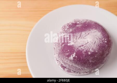 Nahaufnahme von japanischem Purple Sweet Potato Daifuku oder Red Bean Paste Füllung Reiskuchen auf weißem Teller Stockfoto