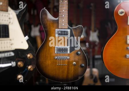 Gebrauchte E-Gitarren, die in gebrauchten Schaufenstern für alte Instrumente zum Verkauf stehen. Stockfoto