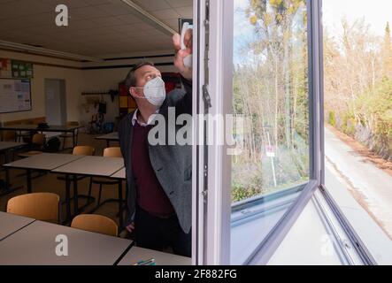Hildesheim, Deutschland. April 2021. Rene Mounajed, Geschäftsführer des Niedersächsischen Schulmanagements und Schulleiter der Robert Bosch Comprehensive School in Hildesheim, öffnet Fenster in einem Klassenzimmer seiner Schule. Der Start der obligatorischen Corona-Selbsttests für Schüler und Lehrer war aus Sicht des Niedersächsischen Schulmanagements chaotisch. Quelle: Julian Stratenschulte/dpa/Alamy Live News Stockfoto