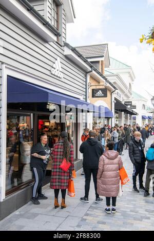 CANNOCK, STAFFORDSHIRE, GROSSBRITANNIEN. April 2021. Nicht unbedingt erforderliche Geschäfte dürfen heute ihre Türen für Käufer öffnen. Der Designer Outlet-Einkaufskomplex in Cannock, Staffordshire, öffnete heute zum ersten Mal seine Türen, nachdem er kürzlich fertiggestellt wurde. Vor den Designerläden warten große Warteschlangen. Rund 50 Käufer warten darauf, bei Adidas einzusteigen. Kredit: Richard Grange/Alamy Live Nachrichten Stockfoto