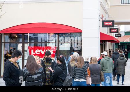 CANNOCK, STAFFORDSHIRE, GROSSBRITANNIEN. April 2021. Nicht unbedingt erforderliche Geschäfte dürfen heute ihre Türen für Käufer öffnen. Der Designer Outlet-Einkaufskomplex in Cannock, Staffordshire, öffnete heute zum ersten Mal seine Türen, nachdem er kürzlich fertiggestellt wurde. Vor den Designerläden warten große Warteschlangen. IN LEVIS wartet eine Schlange von rund 30 Menschen darauf, einzusteigen. Kredit: Richard Grange/Alamy Live Nachrichten Stockfoto