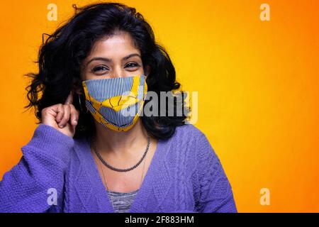 Schöne junge indische Frau posiert mit covid 19 Maske Schutz - hübsches Mädchen aus Sri Lanka nutzt Schutz vor pandemischer Rauchflucht Stockfoto