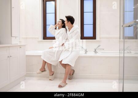 Glückliches junges Paar umarmt im Badezimmer Stockfoto