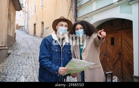 Junge Paar Touristen mit Karte auf Urlaub in der Altstadt, Coronavirus-Konzept. Stockfoto