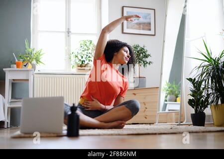 Junge Frau drinnen zu Hause, tun Übung. Sportkonzept. Stockfoto