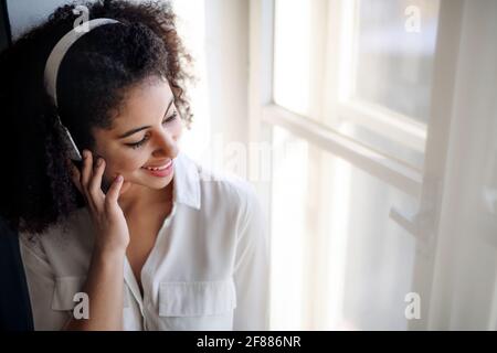 Portrait einer jungen Frau mit Kopfhörern zuhause, Musik hören. Stockfoto
