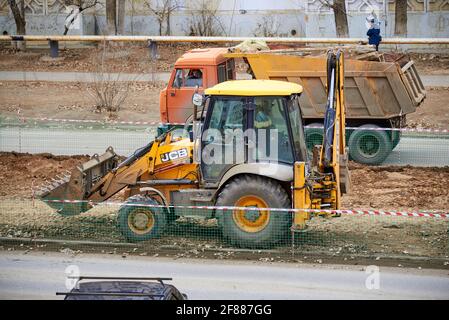 Astrachan, Russland - 02.15.2021: JCB Backhoe Loader and Dump Truck Stockfoto