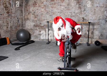 Fitness. Lustiger Weihnachtsmann und Fitnessstudio. Stockfoto