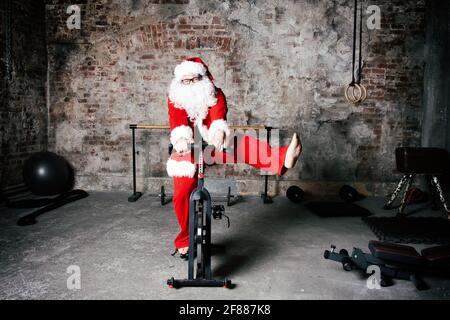 Fitness. Lustiger Weihnachtsmann und Fitnessstudio. Stockfoto