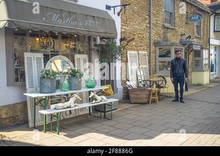 Woodstock, Oxfordshire, Großbritannien, 12. April 2021. England machte am Montag seinen nächsten Schritt aus der Blockierung des Coronavirus, wobei beide nicht wichtigen Einzelhandelsgeschäfte wieder eröffnet wurden. IM BILD: Ein Mann wartet außerhalb von Martha's Attic, das einen stetigen Einkaufsstrom hatte. Bridget Catterall/Alamy Live News Stockfoto