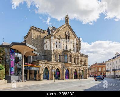 Das York Theatre Royal aus dem 18. Jahrhundert mit seinem modernen Foyer. Die Leute warten an den Bögen auf einen Bus und ein Himmel mit Wolken ist oben. Stockfoto