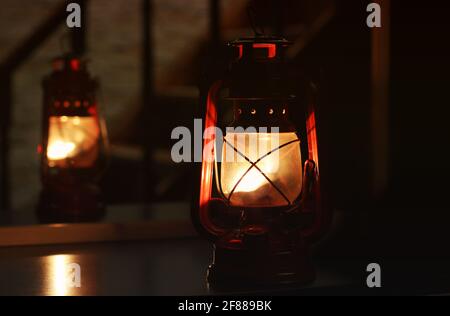 Petroleumlampe im Dunkeln. Die Lampe in der Nähe des Spiegels Stockfoto