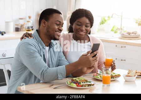 Happy African American Ehegatten Mit Smartphone Beim Frühstück In Küche Stockfoto