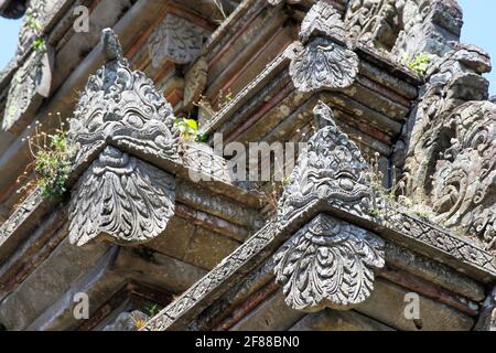 Traditionelle Steinschnitzereien von Gesichtern auf dem Dach des Gebäudes in Bali, Indonesien Stockfoto