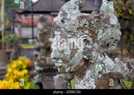 Nahaufnahme der traditionellen, mit Moos verkrusteten Statue am Tempel in Bali, Indonesien Stockfoto