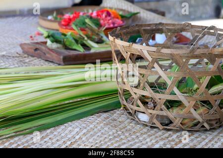 Gewebter Korb, grünes Bananenblatt und Blumen für die Herstellung von Canang Sari in Bali, Indonesien Stockfoto