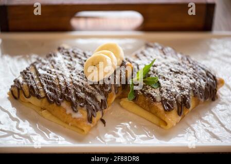 Bananenpfannkuchen mit Schokoladensirup zum Frühstück Stockfoto