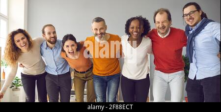 Banner mit einem Team von glücklichen, vielfältigen Menschen, die sich zusammenhuddeln, lachen und Spaß haben Stockfoto