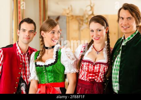 Junge Leute, die sich für traditionelle bayerische Tracht im Restaurant oder im Pub Stockfoto