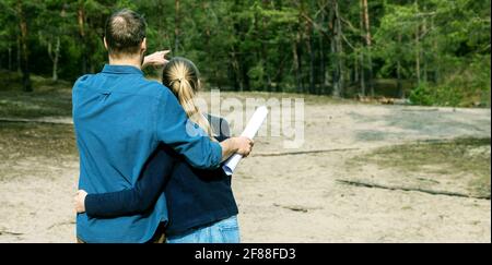 Junges Paar wählen ein Grundstück für Traumhaus Bau im Wald. Platz kopieren Stockfoto