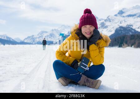 Winterurlaub Reise ins Schneetal - jung glücklich und Aufgeregt asiatische chinesische Frau verspielt auf gefrorenen See im Schnee Berge in den Schweizer Alpen genießen uniq Stockfoto