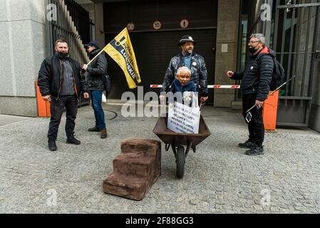 Warschau, 10. April 2021: Ein regierungsfeindlicher Protestler macht eine Geste, während er während des Protestes gegen die Regierung ein Bildnis von Jaroslaw Kaczynski hält Stockfoto