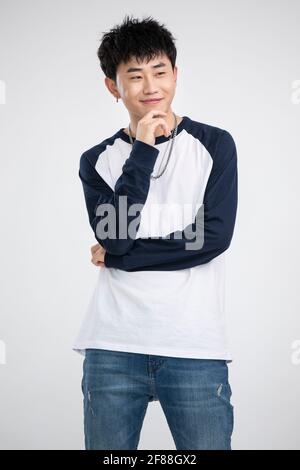 Junger Mann mit Hand am Kinn Stockfoto