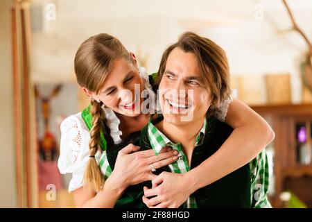 Junges Paar in traditionelle bayerische Tracht im Restaurant oder Pub, konnten die Gastgeber werden. Stockfoto