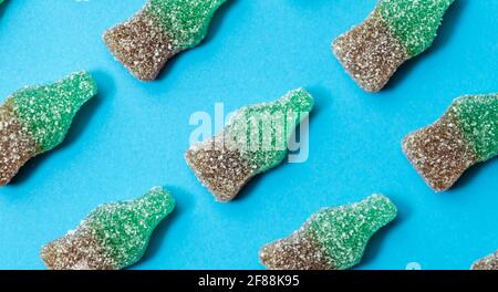 Süßigkeiten Muster.Cola Süßigkeiten Gelee Hintergrund isoliert auf blauem Hintergrund.Draufsicht. Stockfoto