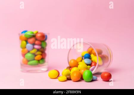 Bunte Schokolade Bonbons im Glas auf blauem Vintage-Holz-Hintergrund.Bunte Süßigkeiten Hintergrundkonzept mit Platz für Text kopieren. Stockfoto